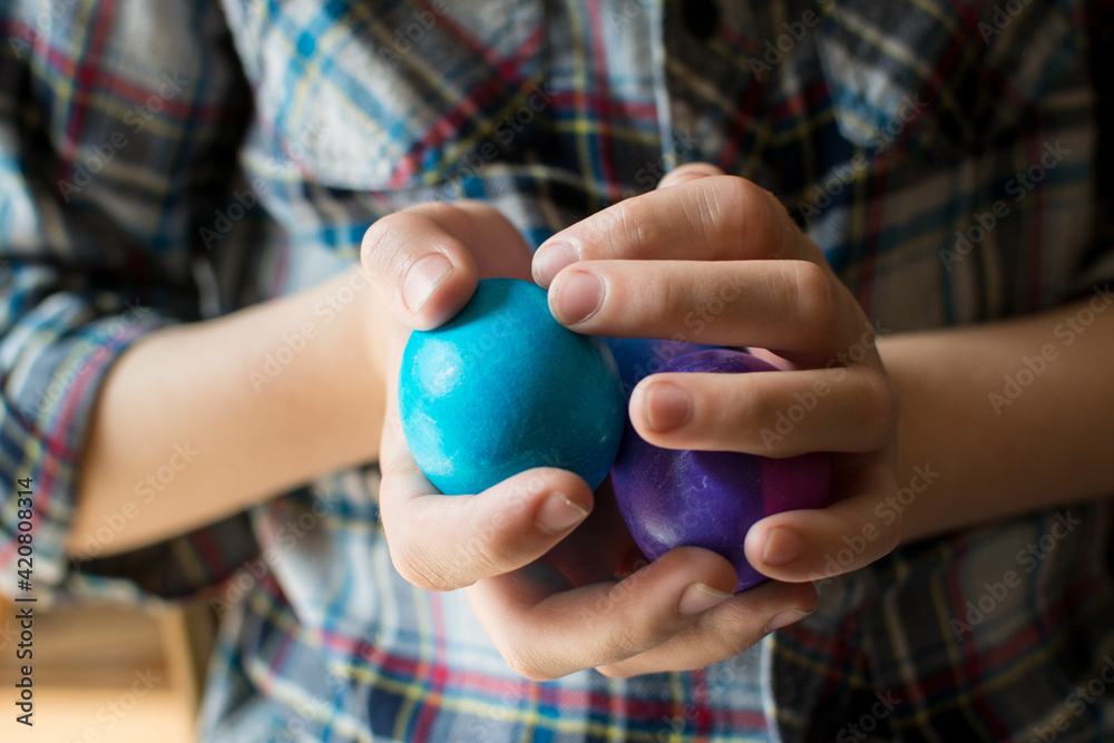 Child holds multiple rubber balls