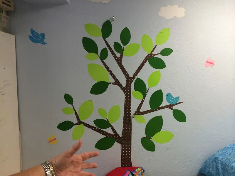 A paper tree with birds decorating the therapy room wall